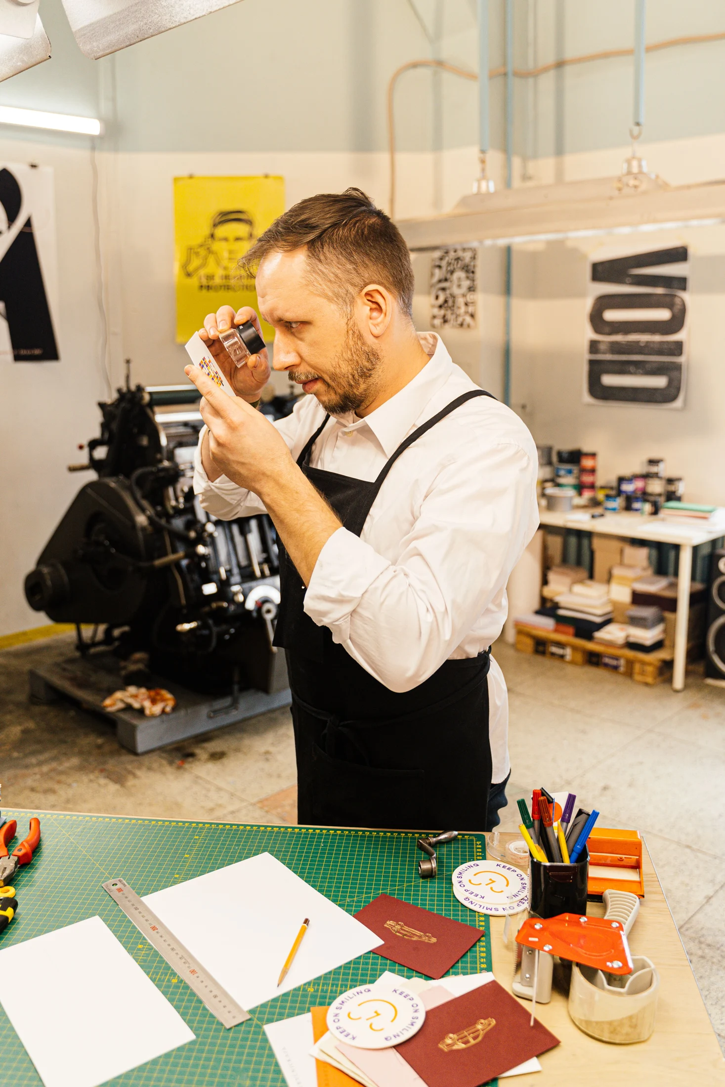Operatore grafico che controlla uno stampato a colori con una lente